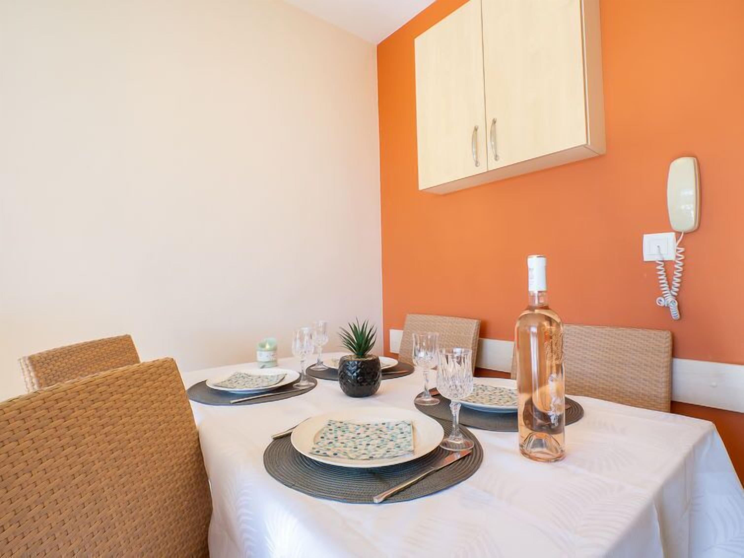 A dining area with a table set for four, including plates, cutlery, and glasses.