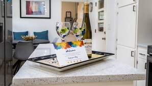 A modern kitchen with a welcome card, two wine glasses, and a bottle of wine on the counter. - Golden Racehorse MCM 3BR Slps 6 - 7 Min to Oaklawn (Hot Springs)