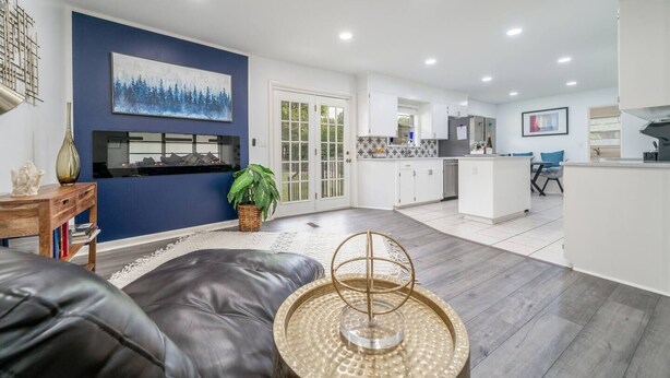 A modern living room with a black leather sofa, a wooden coffee table, and a large painting on the wall. - Golden Racehorse MCM 3BR Slps 6 - 7 Min to Oaklawn (Hot Springs)