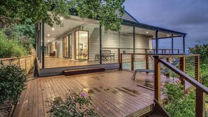 A modern house with a wooden deck, large glass windows, and a view of the garden. - Hanging Garden On Mernda- Mountain view retreat  (Olinda)