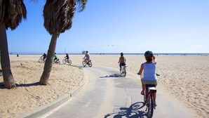 Un camino pavimentado junto a la playa con ciclistas y peatones.