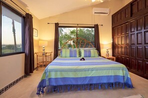 Ein Schlafzimmer mit einem Bett, zwei Nachttischen, einem Fenster mit Vorhängen und einem Holzschrank.