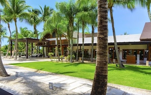 Un resort con palmeras, un césped cuidado y un edificio con techo de tejas.