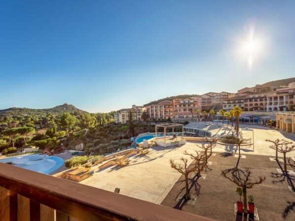 A resort with a pool, outdoor seating, and a view of the surrounding landscape.