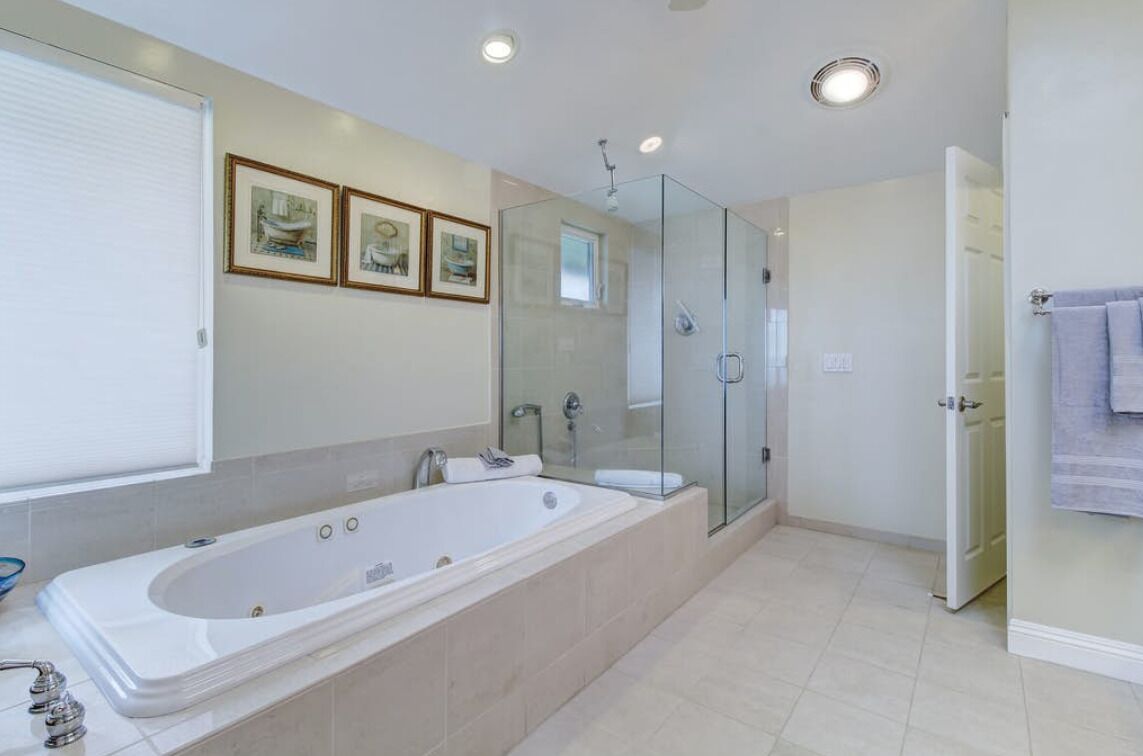 Un bagno moderno con una vasca da bagno spaziosa, un box doccia in vetro e un water.