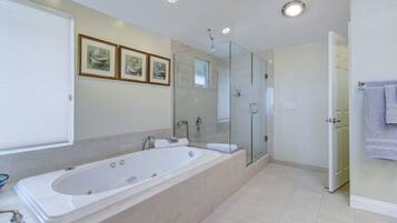 Un bagno moderno con una vasca da bagno spaziosa, un box doccia in vetro e un water.