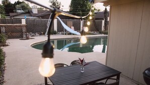 A backyard with a pool, a table, and chairs. - The Desert Sunset: 4 BDR, 5 Beds, Fast Wifi, Large TV, Large private pool, (Mesa)
