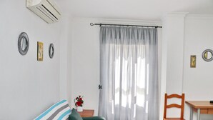 A room with a bed, a chair, a table, and a window with curtains. - First floor Apartment Santa Teresa (Conil de la Frontera)