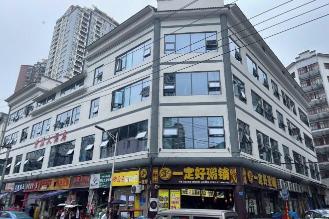 A multi-story building with various storefronts on the ground floor.