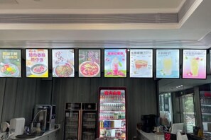 A food service area with digital menu boards displaying various dishes. - Ziteng Hotel (Pengshui County)