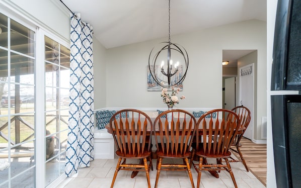 Enjoy meals in this stylish dining area with a dining table, comfortable chairs, and a beautiful chandelier.
