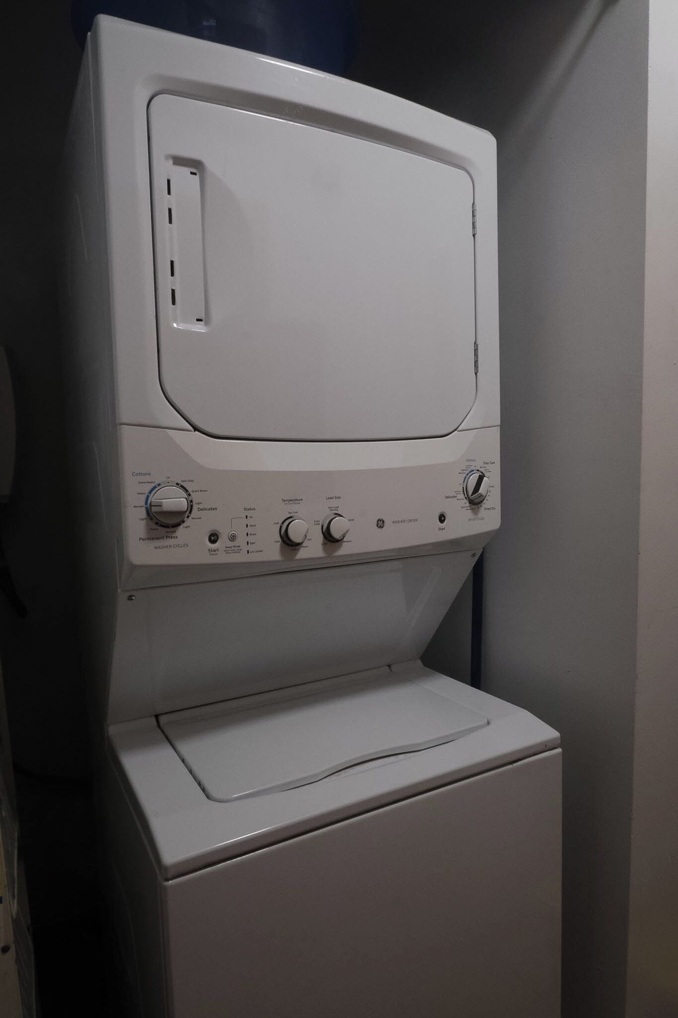 A front-loading washing machine with control knobs and a front-loading dryer.
