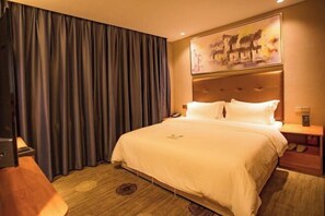Une chambre d’hôtel avec un grand lit, une tête de lit ornée d’un tableau, une table de chevet avec une lampe et une paire de chaussons posés sur le sol.