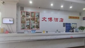 A hotel reception desk with a large glass display case, a computer, and a potted plant. - Wenbo Hotel (Shenzhen Diwang Building Hongling Subway Station) (Shenzhen)