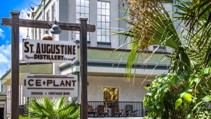 A building with signs for 'St. Augustine Distillery Co.' and 'Ice Plant Dining Vintage Bar'. - Brand New! Heart of Historic St. Augustine, Parking Spot, Balcony, Walk Everywhere, 4 Miles to Beach (St. Augustine)