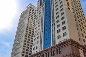 A tall building with multiple floors and a central glass facade.
