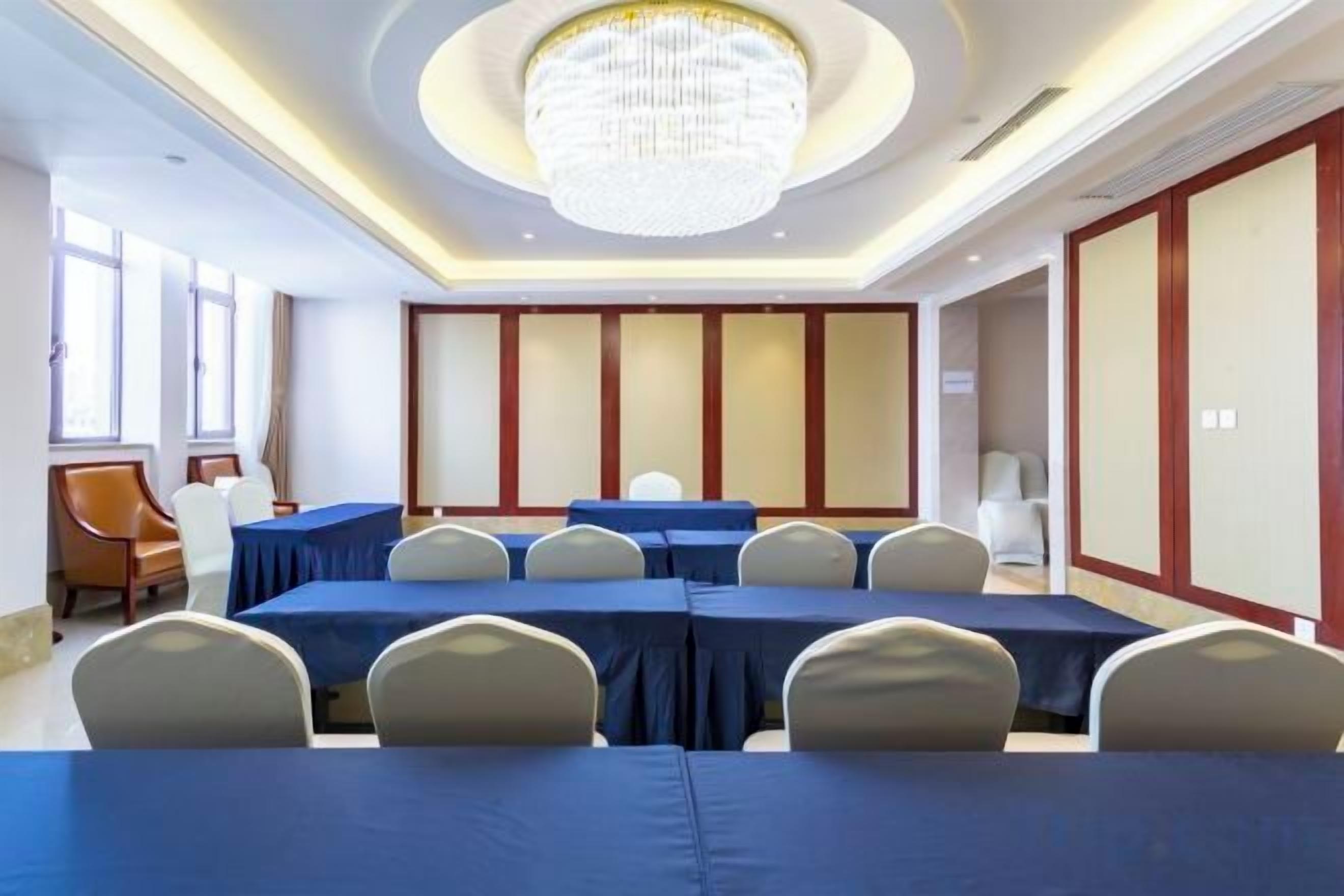 A conference room with a long table, chairs, and a chandelier.