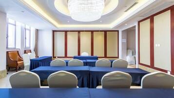 A conference room with a long table, chairs, and a chandelier.