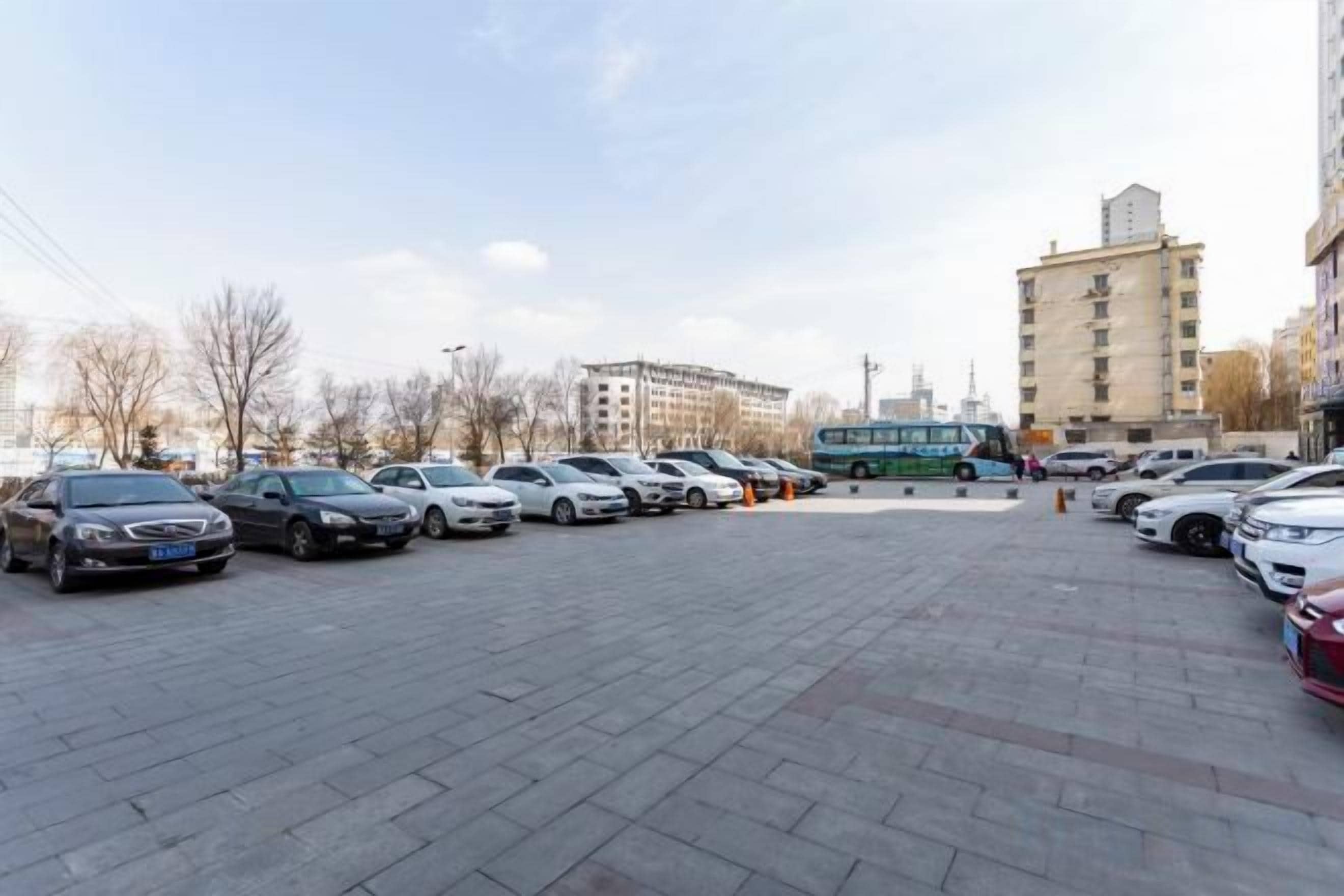 A parking lot with multiple cars and a bus.