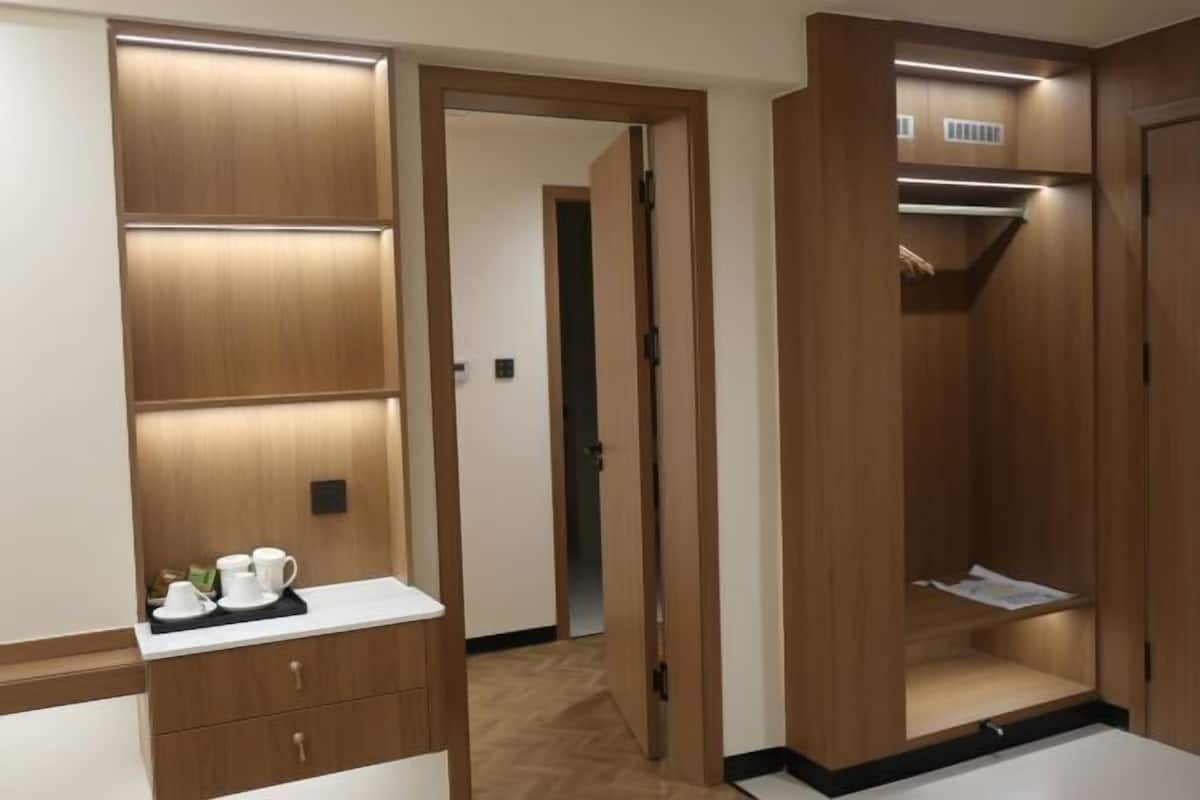 Um closet amplo com portas de madeira, um espelho e uma pequena mesa com xícara e pires.