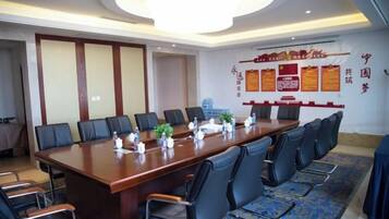 A conference room with a long table, multiple chairs, and a chandelier.