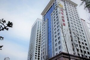 A high-rise building with multiple floors, featuring a prominent entrance and signage. - Guoluo Hotel (Xining)