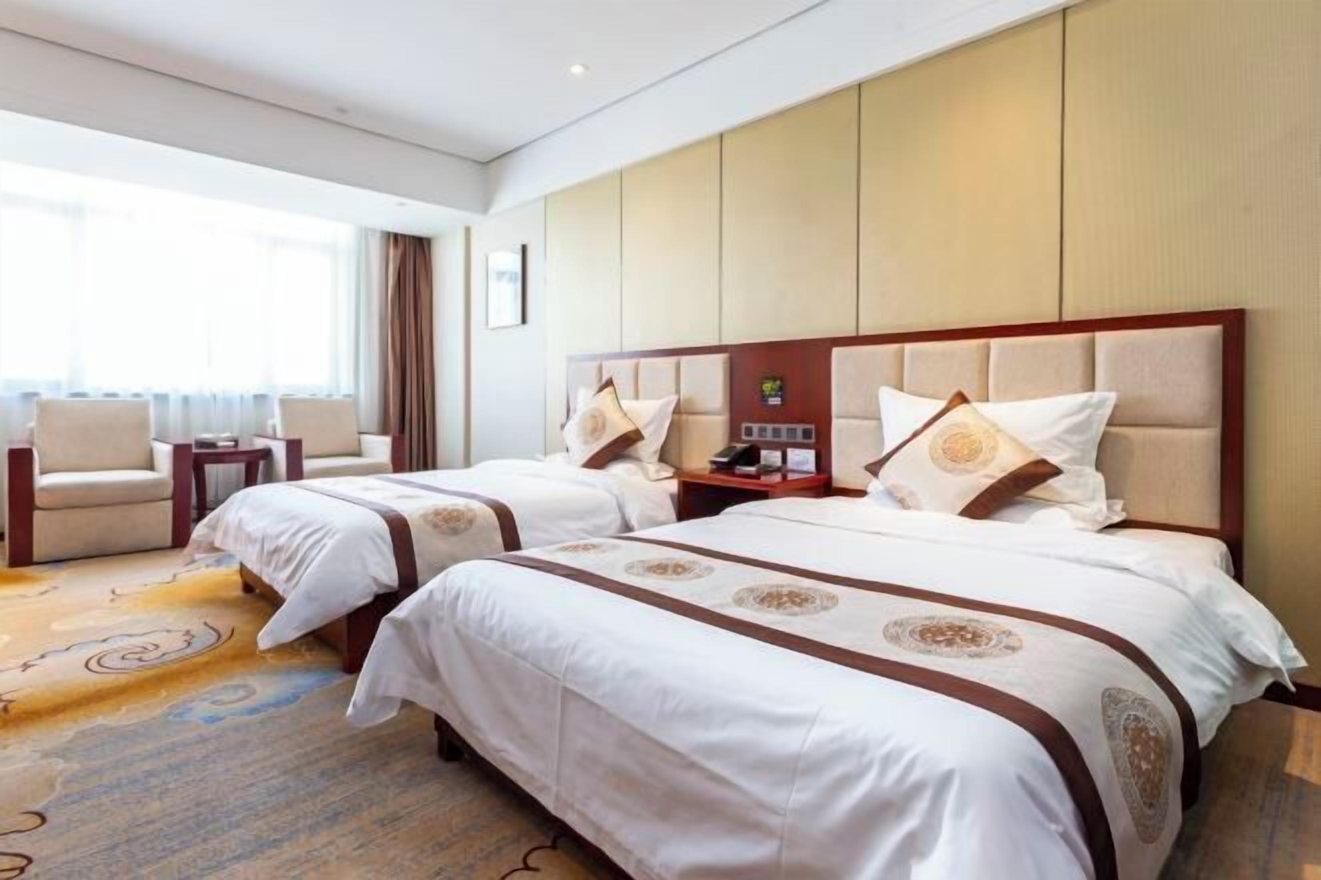 Habitación de hotel con dos camas, un sofá y una mesita.