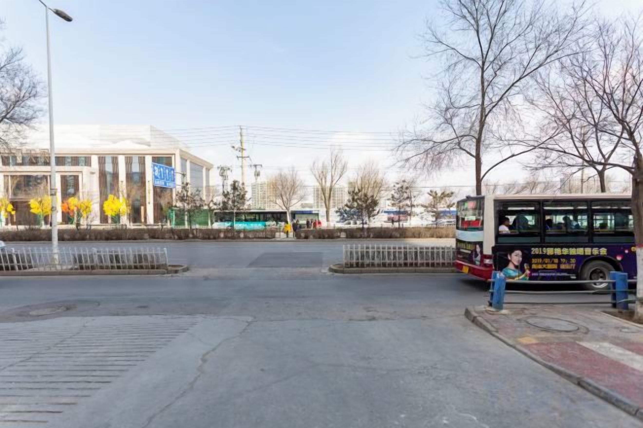 A bus stop with a bus, a pedestrian, and a building in the background.