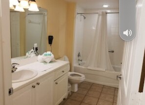 Tina con regadera, secadora de cabello, toallas, papel de baño 