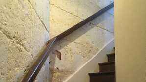Un escalier en bois, doté d’une rampe, menant à un palier.
