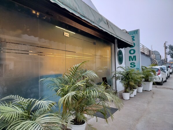 A building with a sign for 'FARMHOUSE INN' and 'KURRY' on the side. There are potted plants in front of the building.