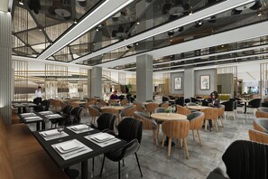 Un vaste espace intérieur aménagé en salle à manger, avec de nombreuses tables et chaises, un plafond haut avec des poutres apparentes et un style moderne.