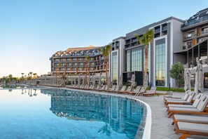 A hotel with a swimming pool, sun loungers, and a modern building with large windows. - Lago Hotel Ex Azura Deluxe Resort and Aqua Sorgun (Manavgat)