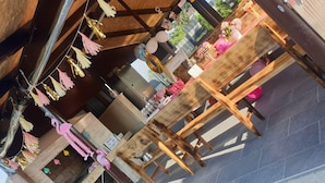 An outdoor dining area with wooden tables and chairs, decorated with hanging tassels and balloons. - Holiday Home Gračec (Brckovljani)