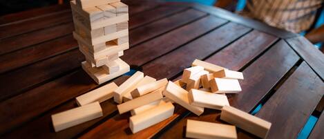 Une table en bois sur laquelle se joue une partie de Jenga.