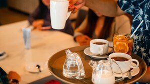 A tray with a teapot, cups, and a glass of iced tea. - JPOD Capsule Hotel (Kota Kinabalu)