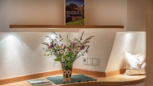 Un bureau en bois orné d’un vase de fleurs, d’un livre et d’un interrupteur fixé au mur.