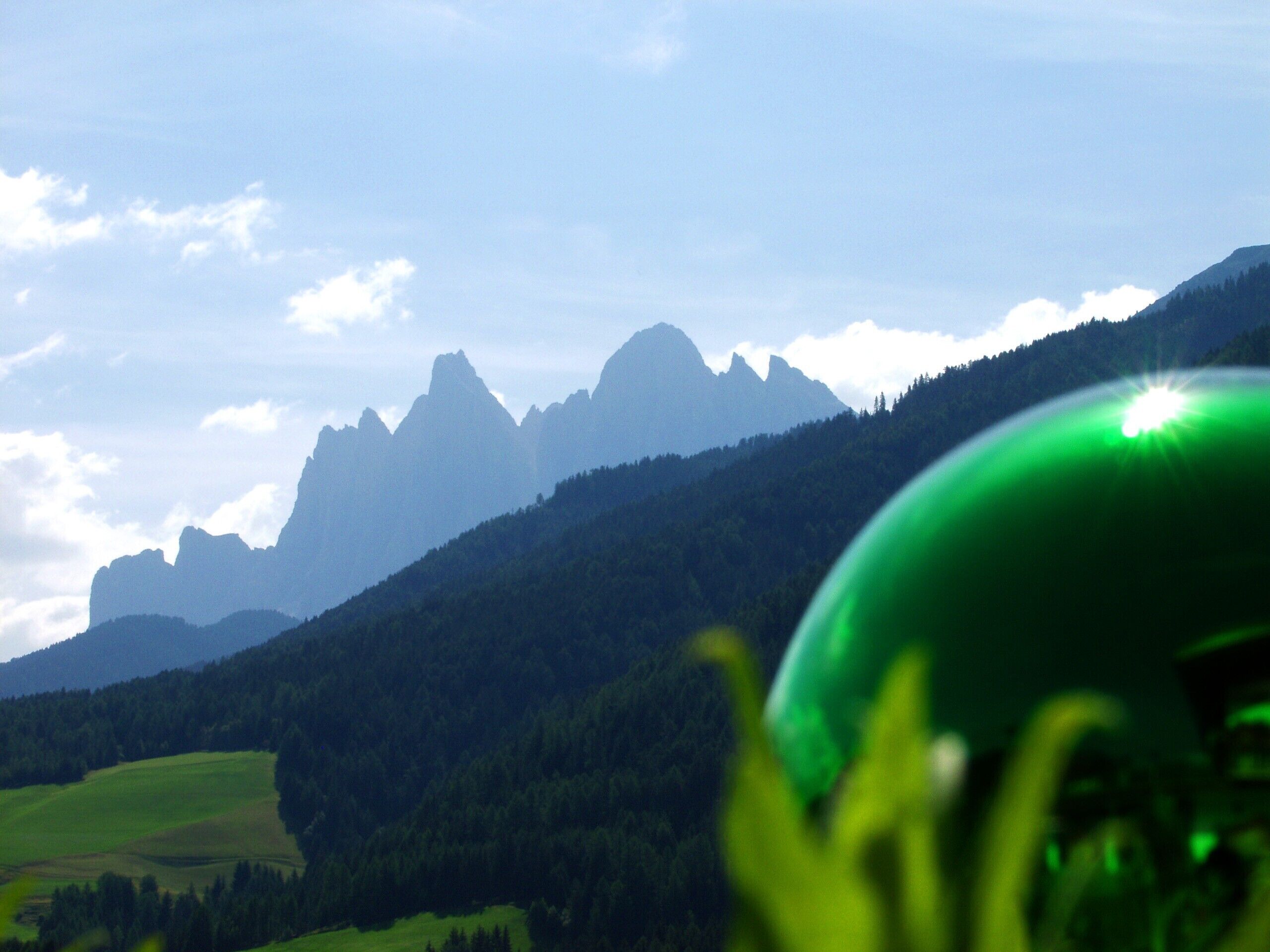 A mountain landscape with a green object in the foreground.