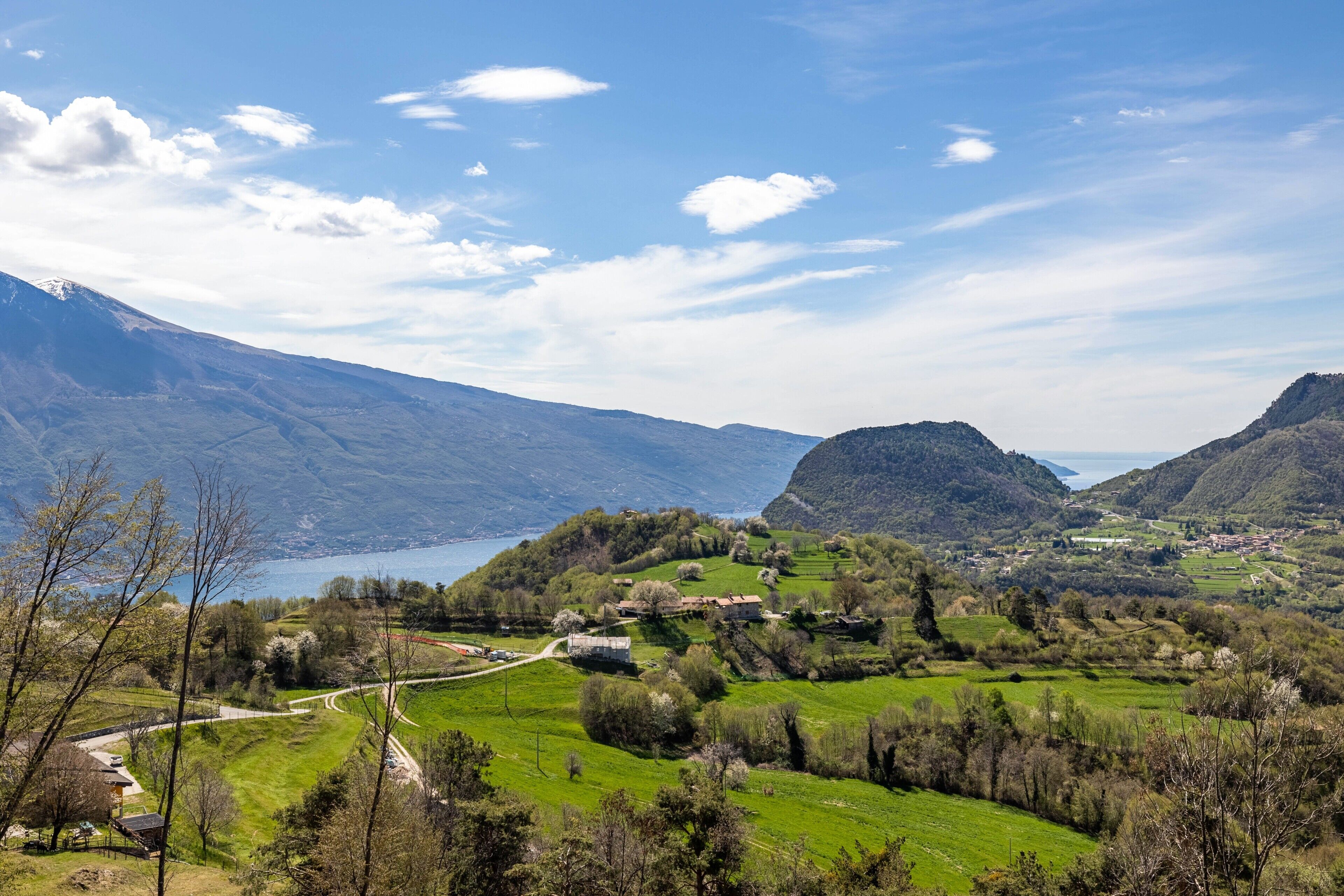 Eine Berglandschaft mit einem See, grünen Feldern und einem Dorf.