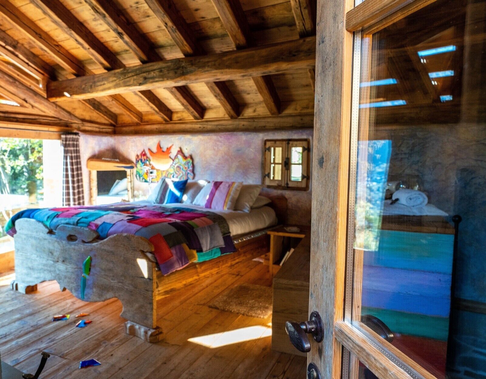 Un intérieur rustique en bois, avec un lit, une petite table et une fenêtre donnant sur un paysage agréable.
