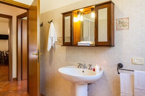 A bathroom with a sink, mirror, towel rack, and a door leading to another room. - Agriturismo 'Trilo Begonia' with Pool, Wi-Fi & Garden (Marina di Grosseto)