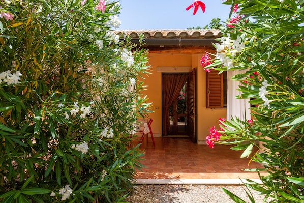 A house with a tiled entrance, a door, and a small porch area.
