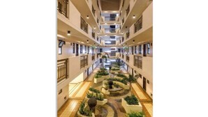 A multi-level hotel atrium with a central courtyard featuring planters and a fountain. - Couple's Getaway|Netflix|Fast net|Parking nr MAKTI (Mandaluyong)