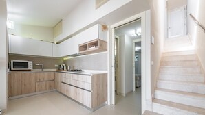 Eine moderne Küche mit Holzausstattung, einer Mikrowelle und einem eingebauten Backofen.