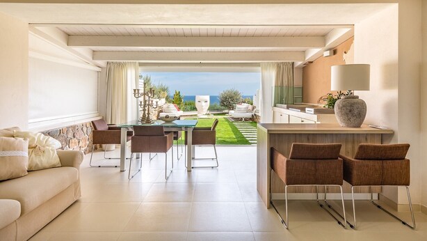Ein modernes Wohnzimmer mit Essbereich, einer Küche und Meerblick.