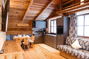 Un intérieur en bois comprenant un coin repas, une cuisine et un espace salon.