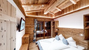 Un intérieur en bois comprenant un lit, un banc et une armoire.