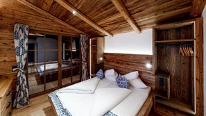 Une chambre dans une cabane en bois, avec un lit, des rideaux et une armoire.