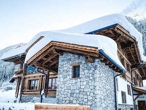 A stone building with wooden beams and a snow-covered roof. - Stadl-suite Peziner-blick - Stadl Chalet Ischgl (Ischgl)