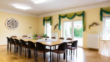 Ein Konferenzraum mit einem langen Tisch, Stühlen und einem Wanddekor.
